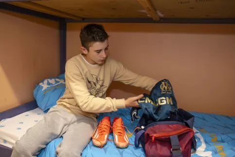 Un jeune de l'internat qui prépare son sac pour son entrainement de foot dans sa chambre de l'internat