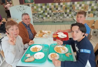 Des jeunes déjeune avec un enseignant