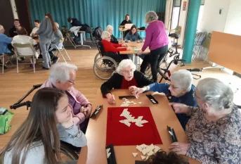 Jeunes et résidents qui jouent au Triomino