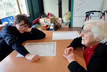 Un jeune et une résidente complète un tableau entre générations