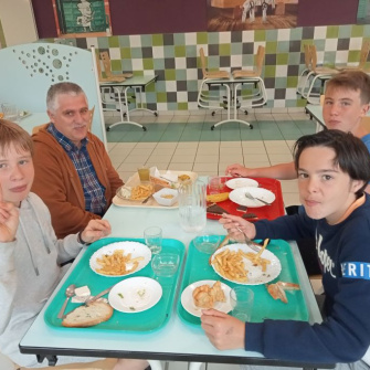 Des jeunes déjeune avec un enseignant